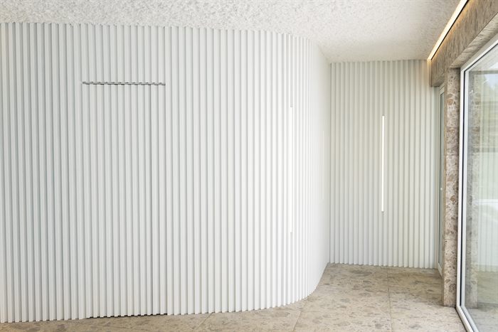 Witte geribde wand langs het bad