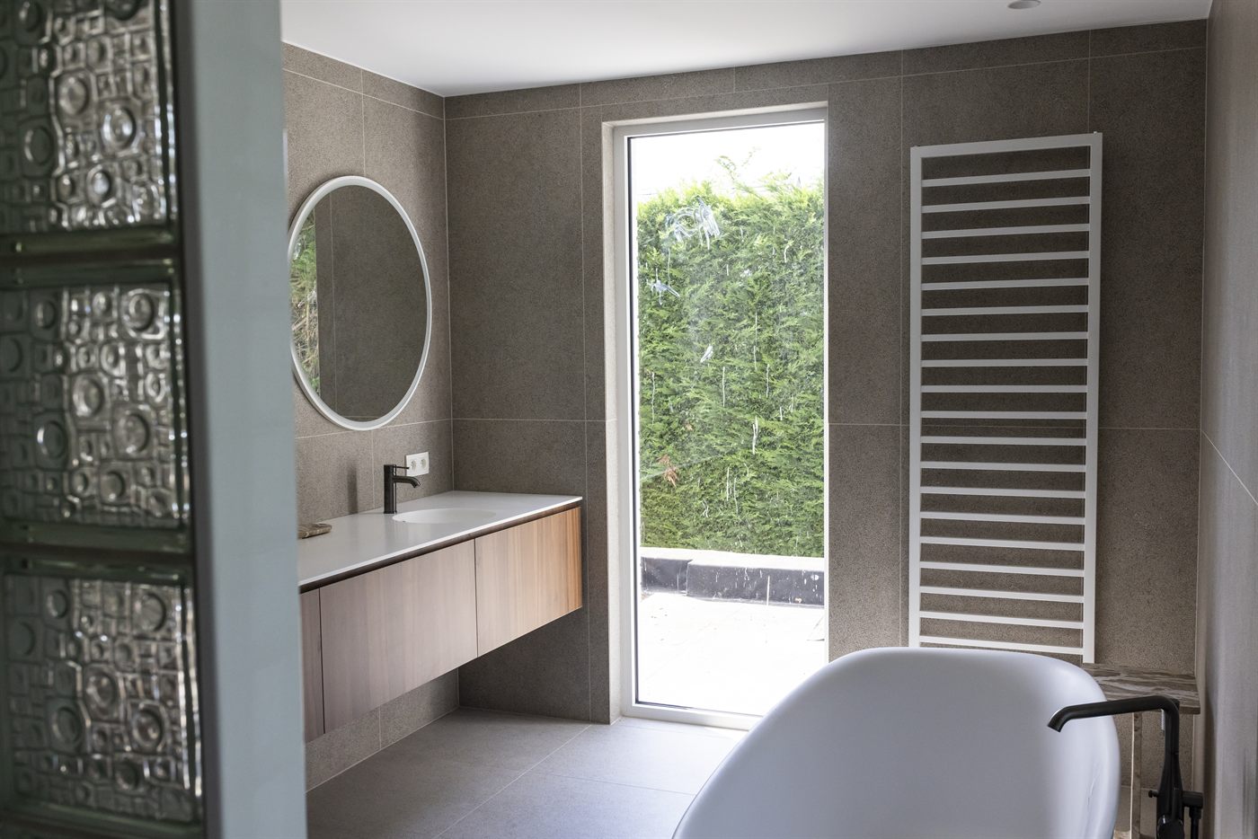 Salle de bains : baignoire îlot devant une paroi en pavés de verre