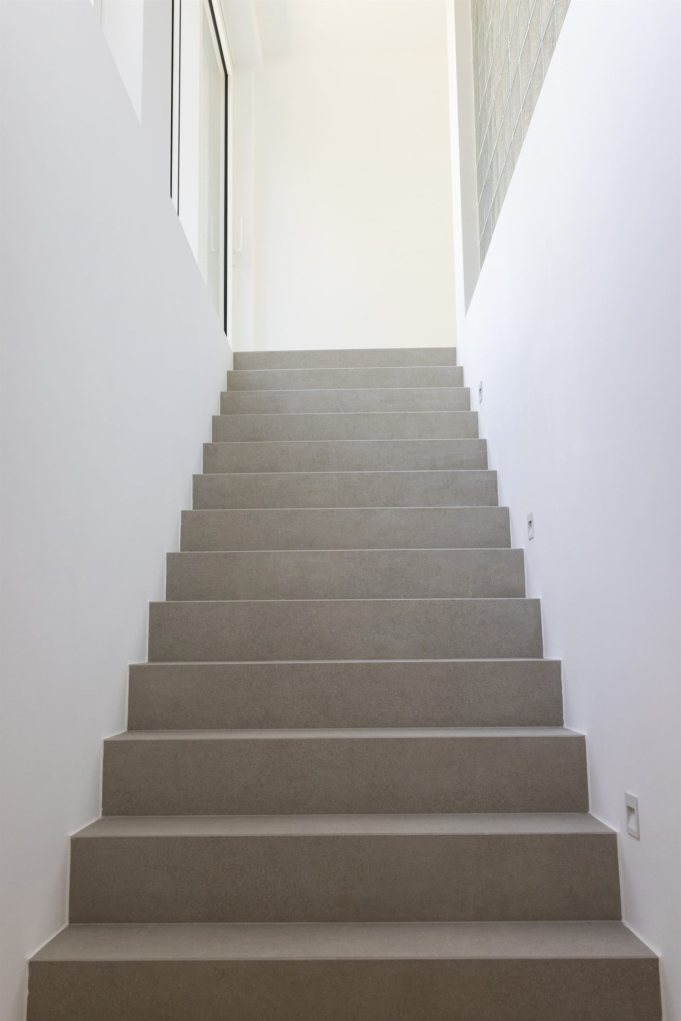Escalier en béton entre deux murs blancs
